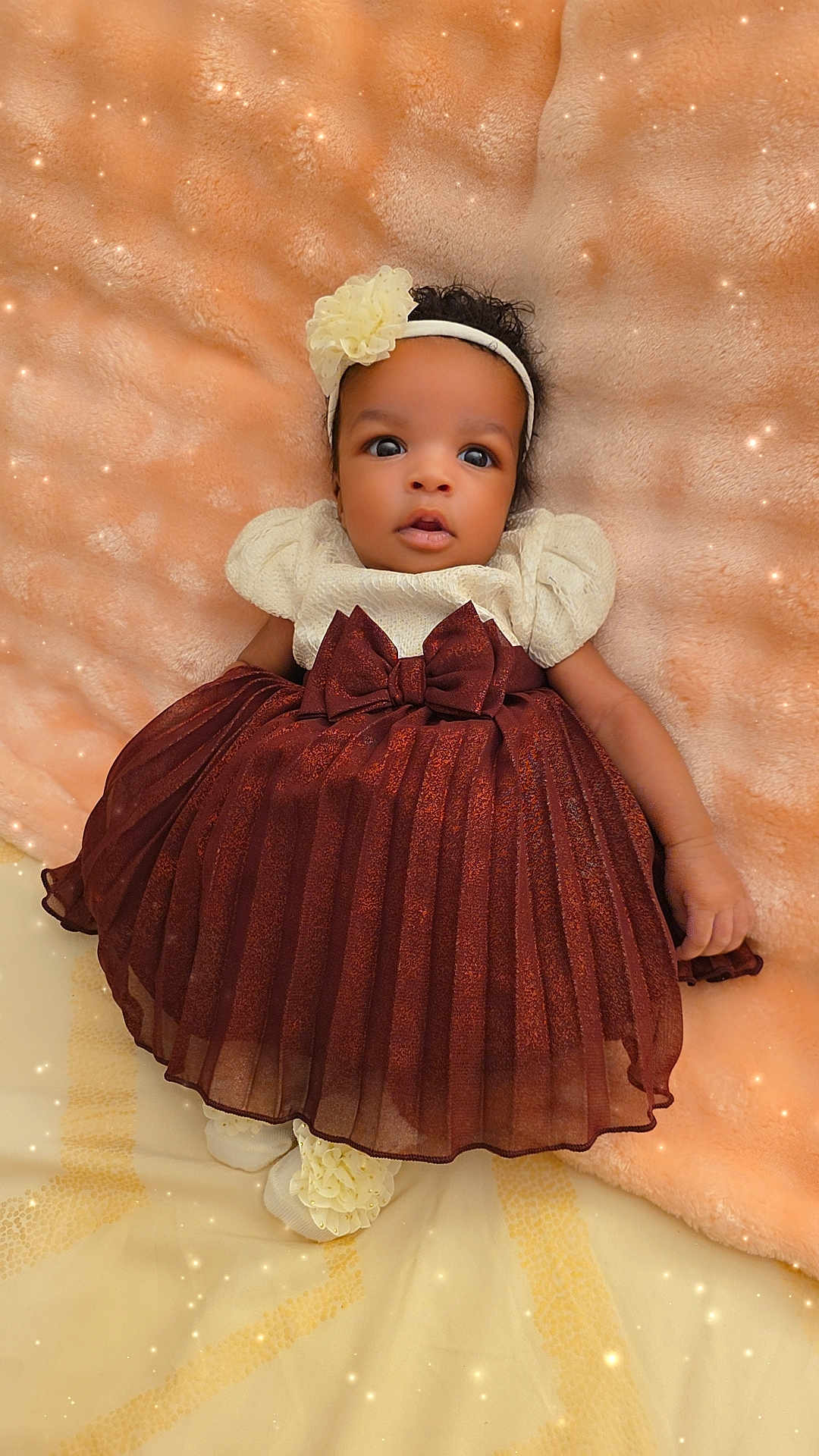 Aliysson Orrico is registered to the contest to win money with this photo: baby, infant, portrait, dress, headband, bow, blanket, soft_texture, lying_down, cute, big_eyes, gaze, socks, ruffles, maroon, peach_background, sparkles, fashion, newborn, studio_style