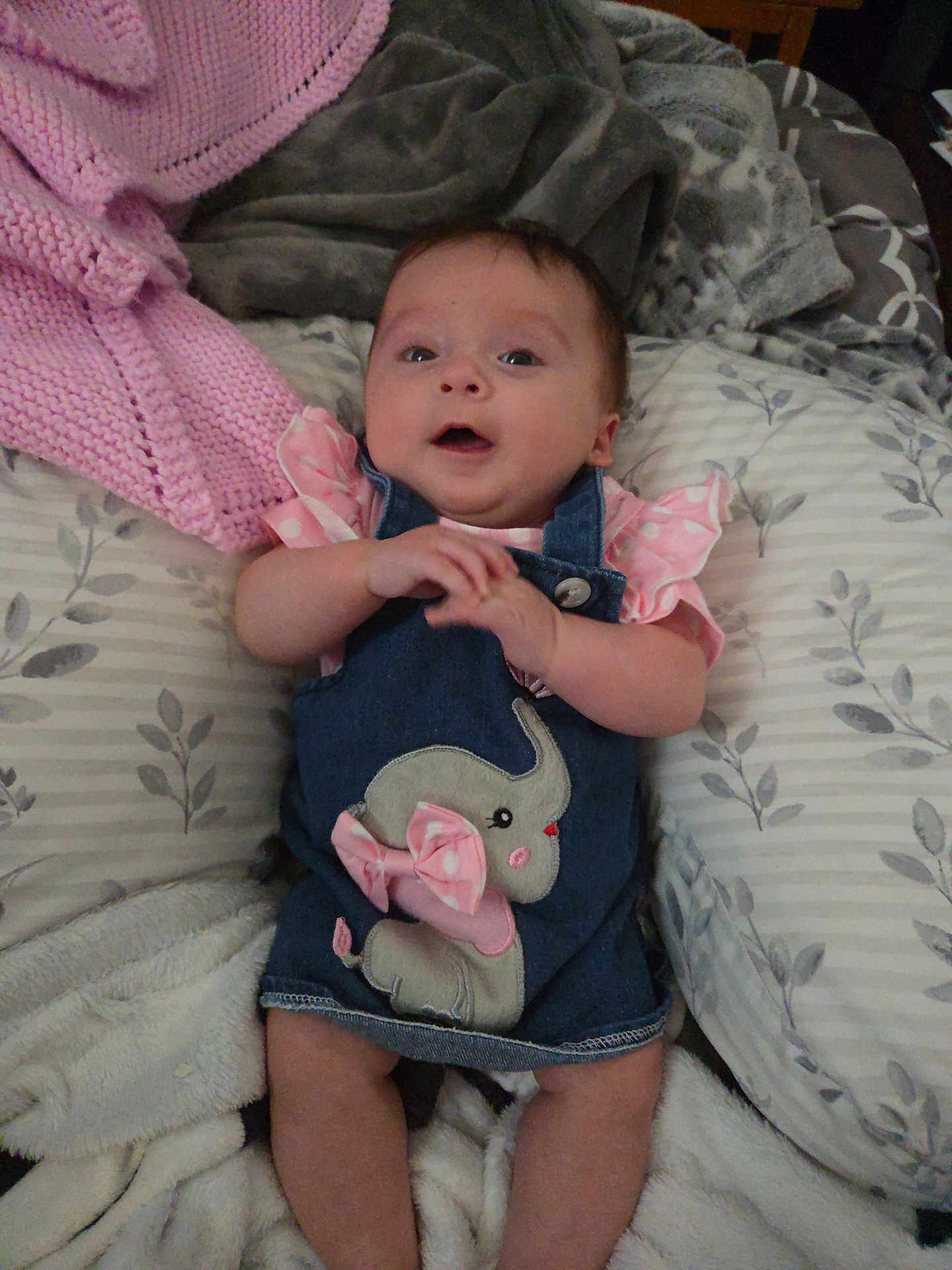 Fiona joined the competition — help win amazing prizes! baby, infant, denim_dress, elephant_applique, pink_clothing, blanket, pillow, bed, soft_texture, cozy, child, cute, indoors, fabric, sleepwear, person, smiling, young_child, lying_down, comfortable