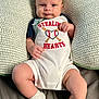 baby, infant, child, pillow, cute, smile, face, legs, socks, clothing, bed, comfortable, pattern, text, baseball, heart, hands, portrait, indoors, lying_down