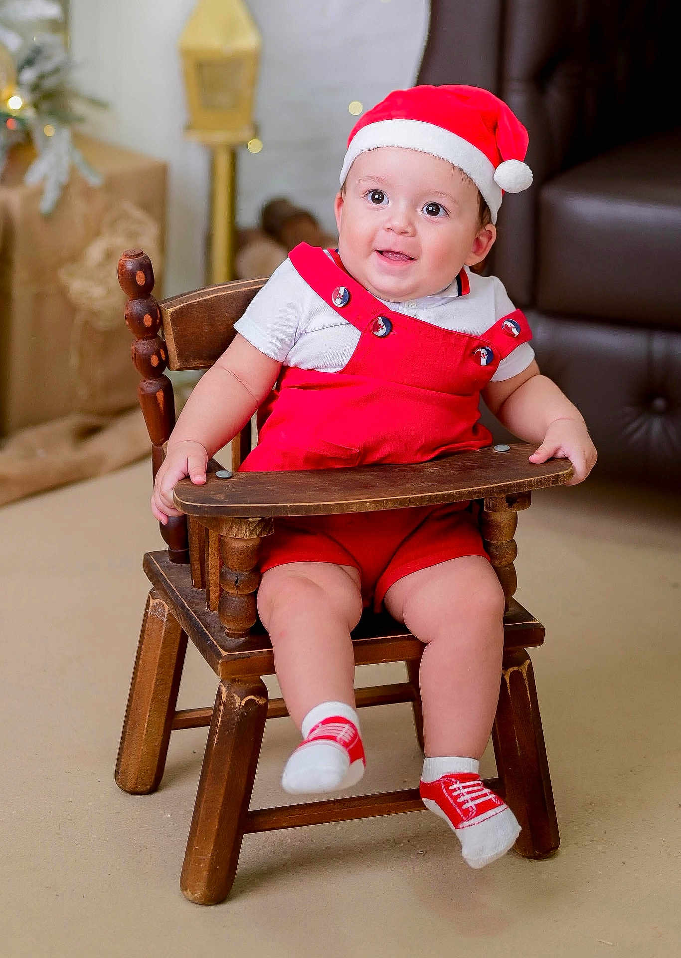 Emmanuel participe au concours pour gagner de l'argent avec cette photo : baby, child, smile, red_overalls, santa_hat, wooden_chair, indoors, happy, festive, holiday, cute, socks, furniture, person, portrait, seated, young_child, infant, warm_lighting, cozy