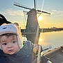 Emmanuel a rejoint le concours — aidez-le/la à gagner de superbes lots ! baby, child, stroller, hat, snack, windmill, sunset, water, reflection, outdoor, nature, sky, clouds, person, cozy, warm, scenic, riverbank, clothing, portrait