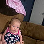 Delilah Rose Knight is registered to the contest to win money with this photo: baby, child, infant, dress, floral_pattern, couch, furniture, indoor, pacifier, pink, brown, blanket, sitting, person, holding, cute, young, face, expression, home