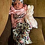 baby, blanket, casual, child, couch, cozy, cute, furniture, headband, indoor, infant, leopard_print, person, pink_clothing, plush_toy, portrait, seated, socks, soft_toy, warm_lighting