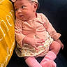 baby, infant, child, portrait, sitting, headband, bow, pink_clothing, floral_skirt, socks, yellow_pillow, cushion, indoor, close_up, face, eyes, baby_fashion, adorable, cozy, photography