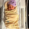 newborn, baby, infant, sleeping, swaddled, blanket, hat, purple_hat, bow, hospital, bassinet, bedding, portrait, face, closed_eyes, peaceful, indoors, nursery, infant_care, photography