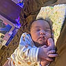 baby, infant, sleeping, portrait, face, hands, finger, onesie, patterned_clothing, pillow, bed, blanket, indoors, cozy, purple_lighting, home, relaxed, cute, newborn, photography