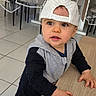 Liam a rejoint le concours — aidez-le/la à gagner de superbes lots ! toddler, child, baby, cap, striped_cap, table, hands, indoor, floor, tiles, curious, eyes, face, clothing, hoodie, long_sleeve, person, leaning, furniture, chair