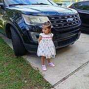 Abigail joined the competition — help win amazing prizes! child, girl, dress, shoes, car, ford, explorer, driveway, sidewalk, grass, speed_limit_sign, outdoor, vehicle, concrete, parking, curb, tree, sky, daylight, casual