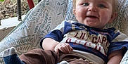Jameson joined the competition — help win amazing prizes! baby, child, smiling, socks, pants, shirt, baby_chair, outdoor, grass, porch, railing, happy, person, face, young_child, casual_clothing, seat, feet, cute, infant