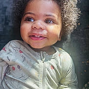 Zyun Sanders is registered to the contest to win money with this photo: toddler, child, smiling, curly_hair, onesie, face, portrait, baby, happy, cute, indoors, soft_light, skin, eyes, mouth, expression, infant, cozy, closeup, person