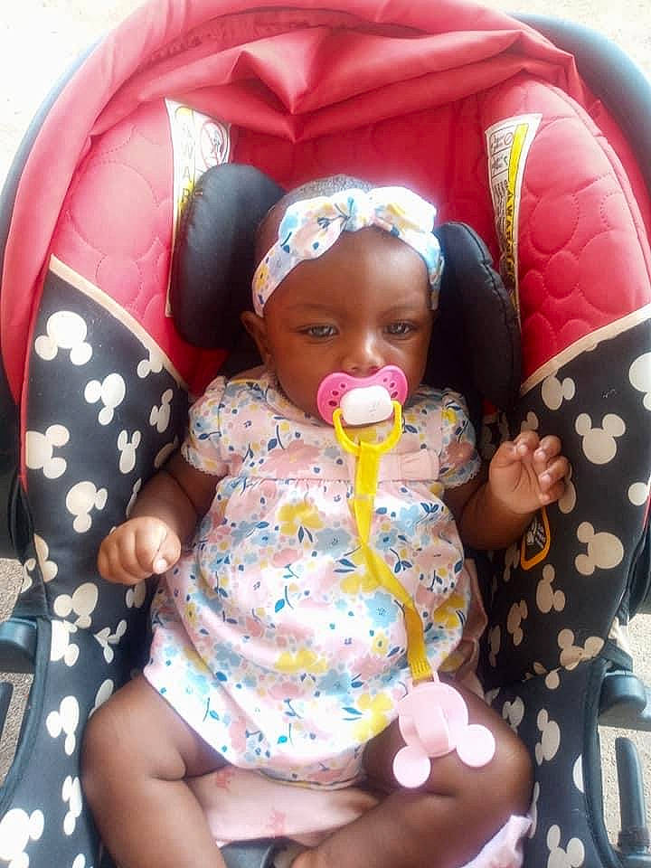 Rayelle is registered to the contest to win money with this photo: baby, baby_products, baby_sleeping, baby_toddler_clothing, cheek, child, comfort, facial_expression, fun, happy, headwear, lap, mouth, pattern, person, pink, product, sitting, skin, textile