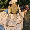 Lelou a rejoint le concours — aidez-le/la à gagner de superbes lots ! animal, creature_lookalike, daytime, dog, grass, greenery, happy, nature, outdoor, pet, playful, river, rock_sculpture, rocks, sculpture, stone, sunlight, tongue_out, water, wet_fur