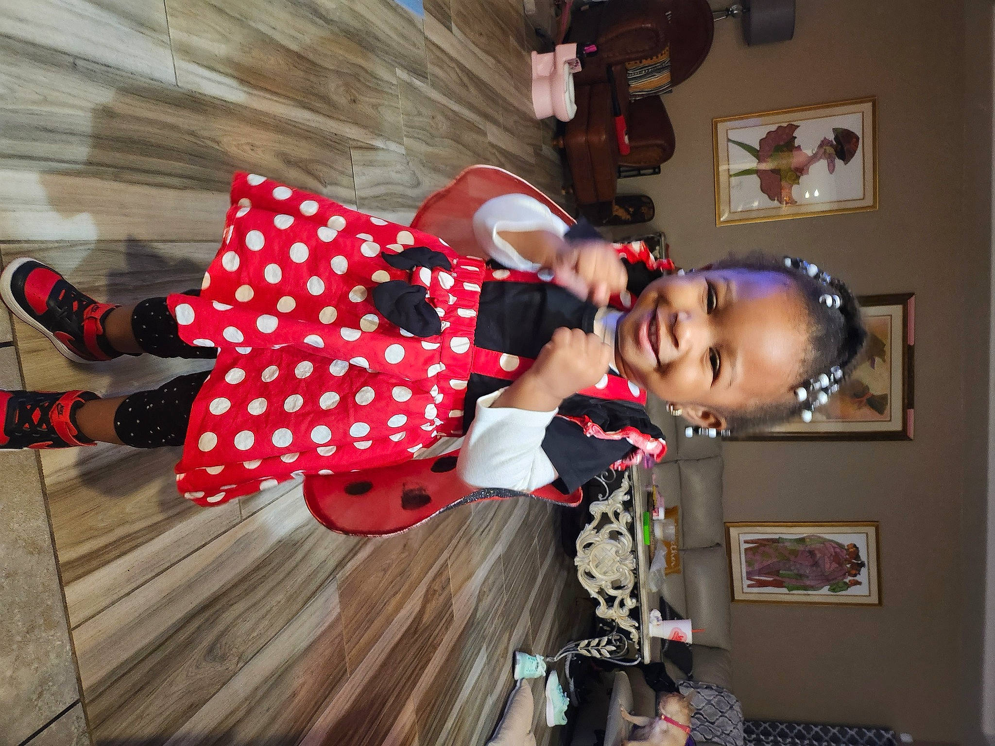 Aaliyah is registered to the contest to win money with this photo: carmine, child, costume, flooring, fun, happy, hardwood, human_leg, joy, pattern, person, picture_frame, plaid, polka_dot, room, smile, thigh, toddler, wood, wood_flooring