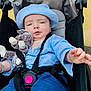 baby, babywearing, blue_clothing, casual_clothing, child, comfort, cute, expression, fabric, hat, infant, outdoor, person, reaching_hand, seat, seatbelt, stroller, stuffed_animal, toy, young_child