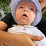 élio participe au concours pour gagner de l'argent avec cette photo : adult, baby, bucket_hat, casual, child, closeup, curious, embroidery, face, greenery, hand, hat, holding, nature, outdoor, person, portrait, skin, smile, white_shirt