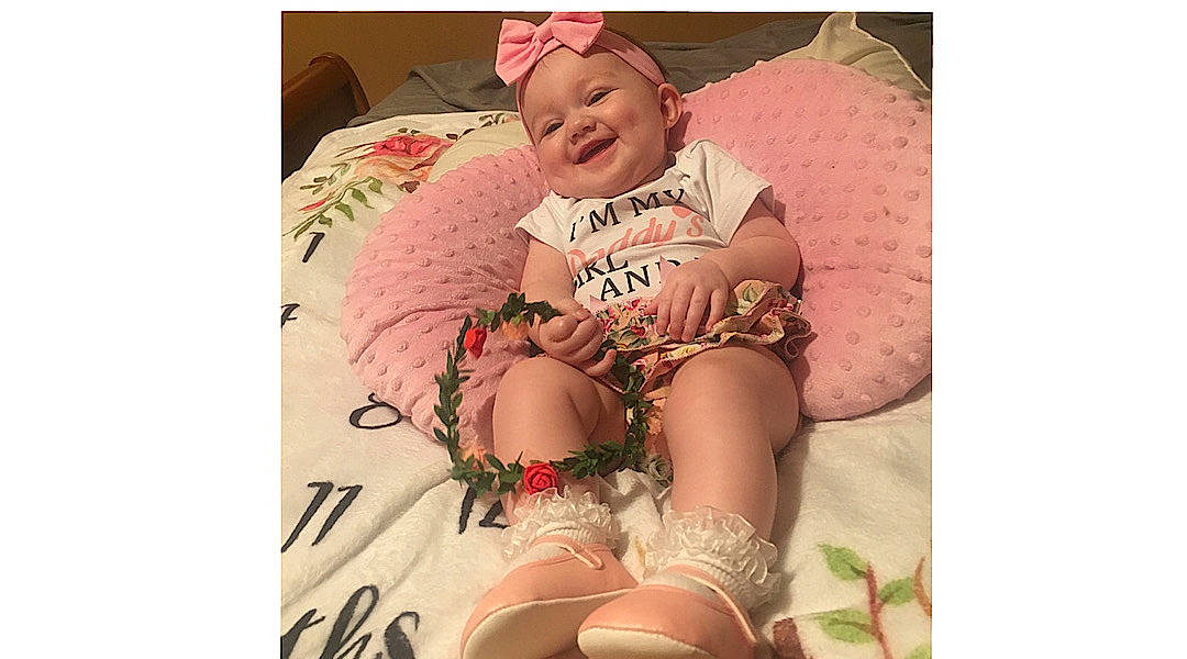 Delilah is registered to the contest to win money with this photo: abdomen, baby, baby_sleeping, baby_toddler_clothing, cap, child, comfort, event, face, font, happy, headwear, human_leg, joy, linens, pattern, person, pink, sleeve, smile