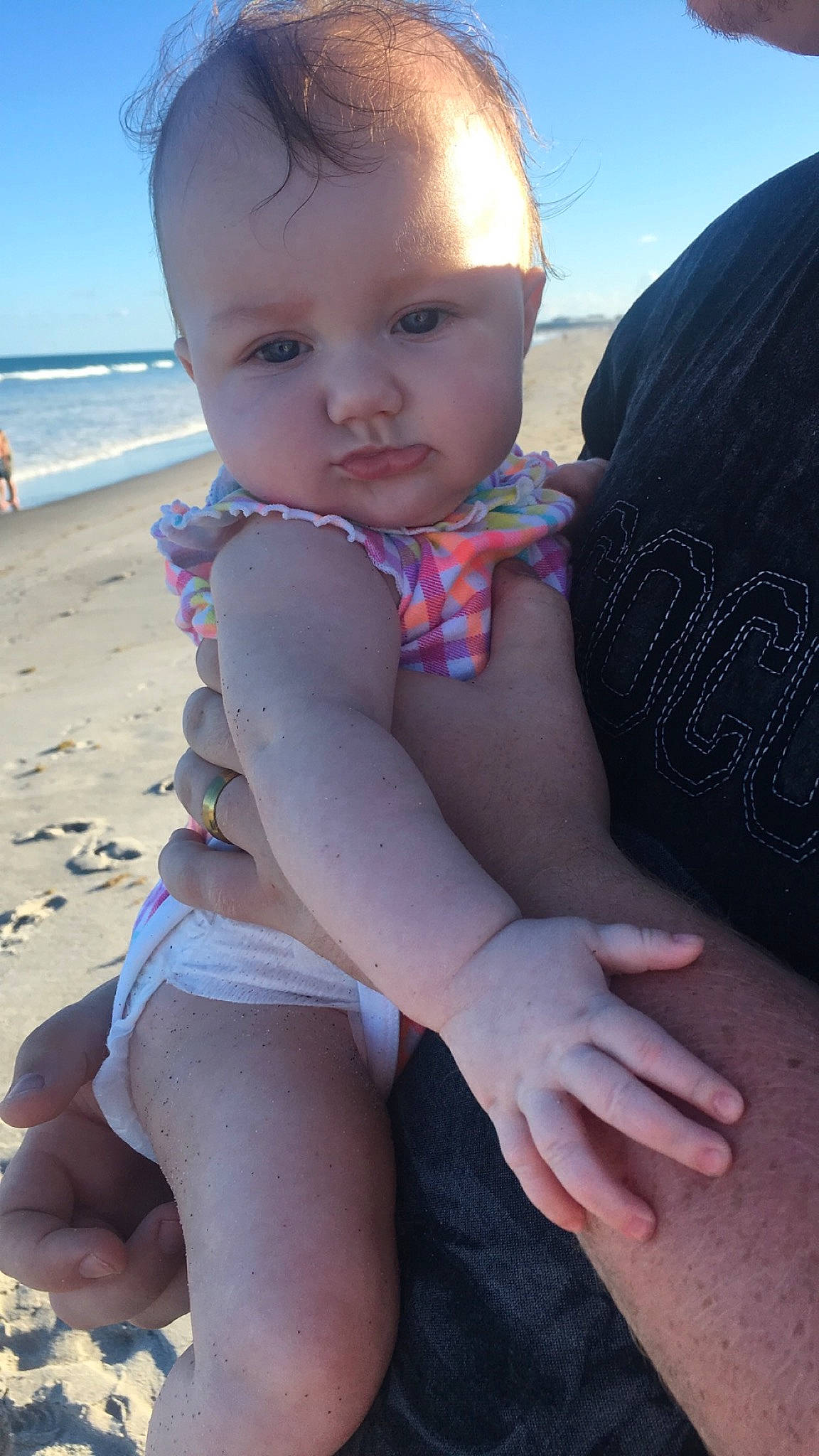 Delilah joined the competition — help win amazing prizes! baby, baby_toddler_clothing, beach, eye, facial_expression, finger, hairstyle, hand, happy, head, joint, knee, leg, organ, person, skin, sky, swimwear, thigh, toddler
