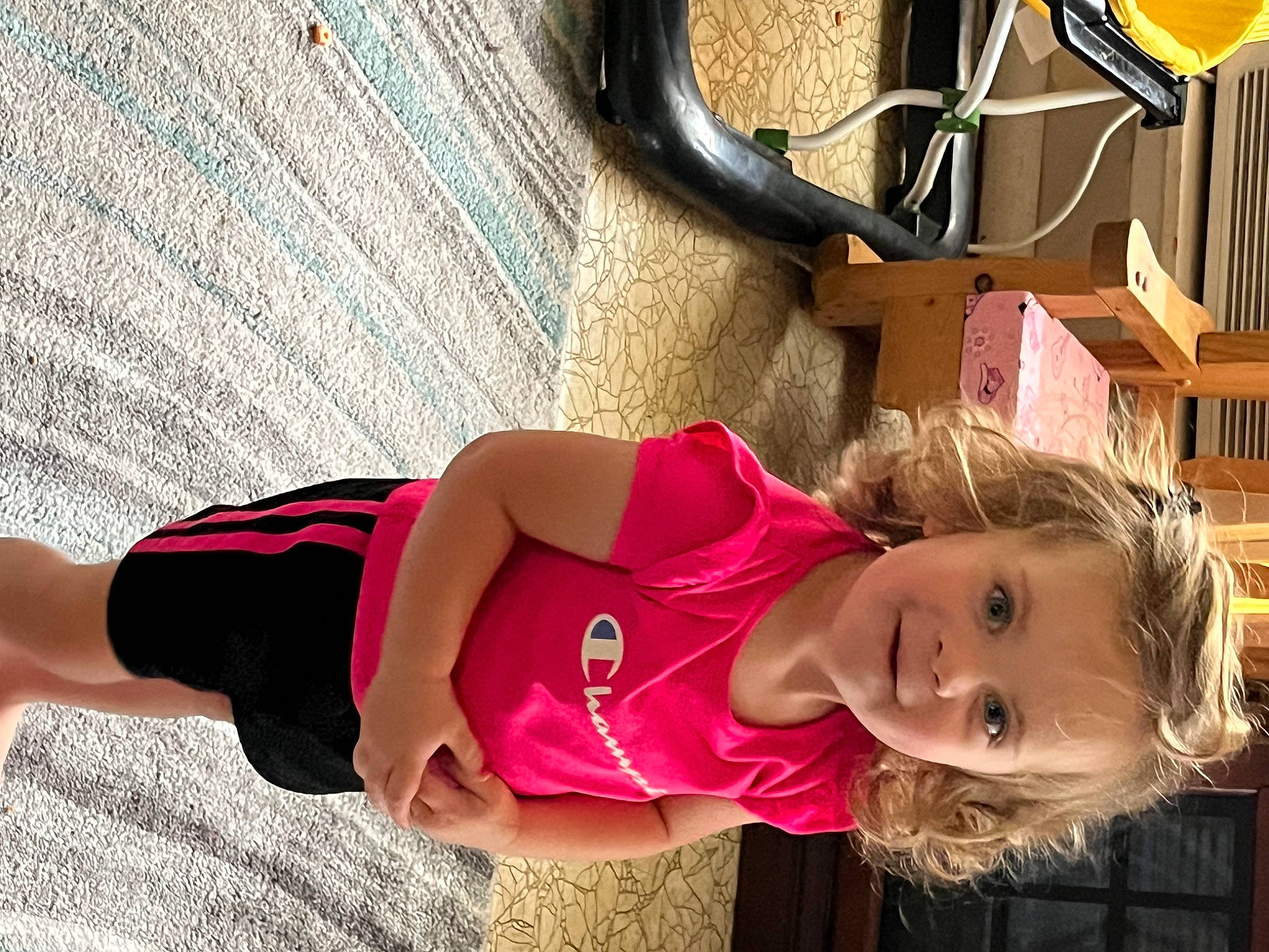 Emily is registered to the contest to win money with this photo: automotive_tire, child, eyewear, fun, happy, hat, human_leg, joy, leisure, magenta, people, person, sitting, smile, tire, toddler, tree, vacation, wheel, white