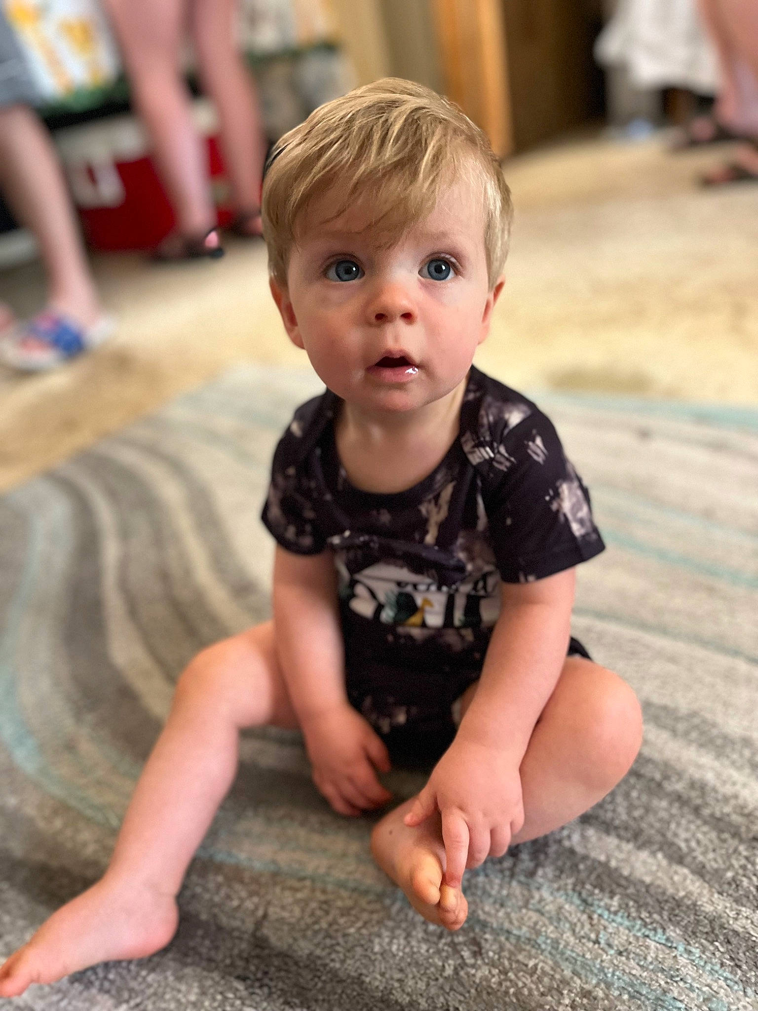 Lance is registered to the contest to win money with this photo: baby, baby_toddler_clothing, beauty, cheek, child, chin, facial_expression, floor, flooring, fun, hairstyle, happy, mammal, person, sitting, skin, sleeve, snapshot, surprise, t_shirt