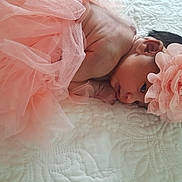 Jennah a rejoint le concours — aidez-le/la à gagner de superbes lots ! baby, newborn, flower_headband, peach_color, tutu, blanket, infant, lying_down, cute, soft_texture, portrait, closeup, sleepy, delicate, skin, head, hands, peaceful, indoors, resting