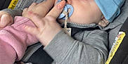 Jaxon joined the competition — help win amazing prizes! baby, blanket, blue_hat, car, car_seat, child, closeup, cute, grey_clothing, hand, holding, indoor, infant, pacifier, person, portrait, seatbelt, smartphone, technology, young_child