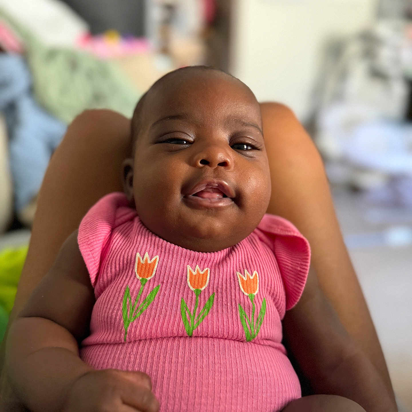 Julia joined the competition — help win amazing prizes! baby, child, person, infant, pink_clothing, tulip_design, smiling, portrait, indoor, skin, face, hand, legs, seated, cute, happy, young, closeup, expression, candid