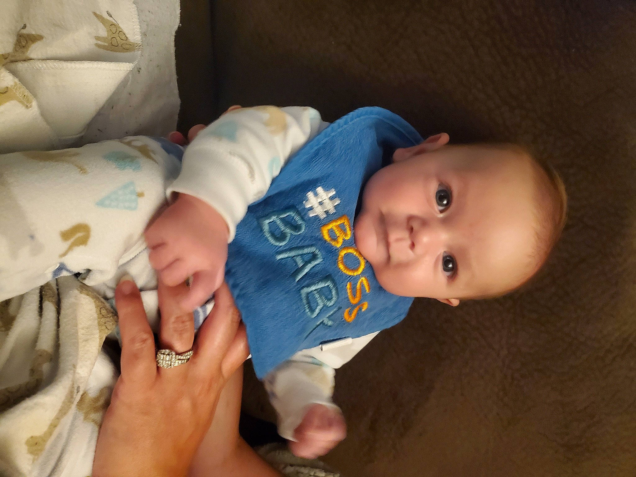 Phoenix is registered to the contest to win money with this photo: baby, baby_products, baby_toddler_clothing, cheek, child, comfort, finger, foot, hand, human_leg, iris, mouth, nail, person, sitting, skin, smile, textile, toddler, wood