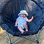 baby, child, smiling, hat, white_clothing, chair, outdoor, wooden_floor, cushion, happy, person, sunlight, deck, can, beverage, relaxing, summer, cute, seat, playful