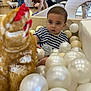 Angus is registered to the contest to win money with this photo: child, toddler, striped_shirt, ball_pit, plastic_balls, plush_toy, chicken_toy, indoor, play_area, people, adult, casual_clothing, curious, seated, playtime, family, background, floor, interaction, toy