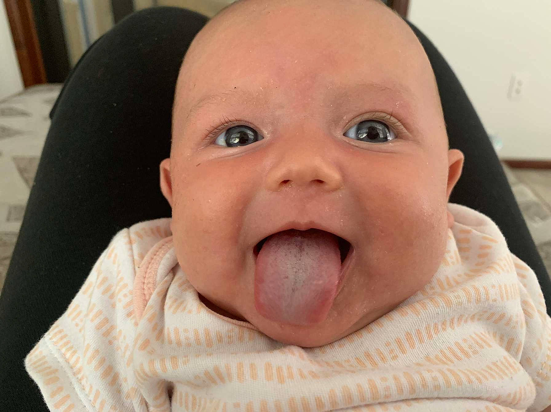 Everly is registered to the contest to win money with this photo: baby, cheek, chin, ear, eye, eyebrow, eyelash, finger, gesture, happy, human_body, iris, jaw, lip, mouth, nose, person, skin, smile, tongue