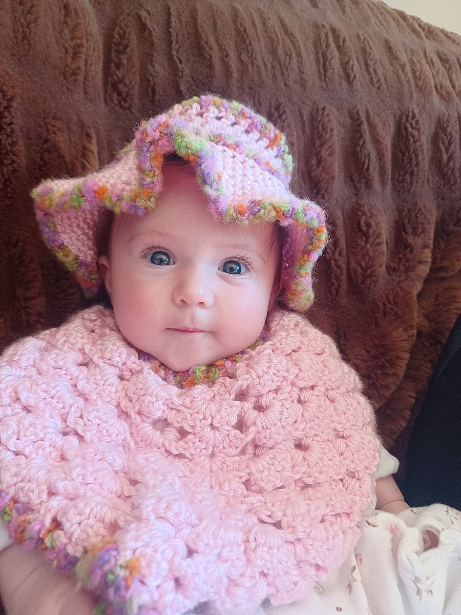 Maria is registered to the contest to win money with this photo: art, baby, baby_toddler_clothing, cap, cheek, creative_arts, dress, eye, face, head, headgear, headwear, iris, knit_cap, lip, person, pink, skin, sleeve, toddler