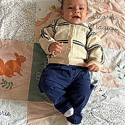 Adam a rejoint le concours — aidez-le/la à gagner de superbes lots ! baby, child, infant, quilt, blanket, animal_illustration, cardigan, pants, sock, smile, lying_down, cute, playful, indoor, text, colorful, soft_lighting, portrait, happy, cozy