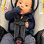 Shai is registered to the contest to win money with this photo: baby, blue_clothing, car_seat, car_seat_warning, casual_clothing, child, child_in_car_seat, curious_expression, cute, hood_with_ears, indoor, infant, person, safety_harness, seated, straps, striped_pants, sucking_thumb, wide_eyes, young_child