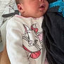 Lïyah a rejoint le concours — aidez-le/la à gagner de superbes lots ! baby, sleeping, newborn, onesie, cartoon, cat, person, hand, arm, clothing, cute, infant, cozy, rest, adorable, soft, indoor, comfort, peaceful, child