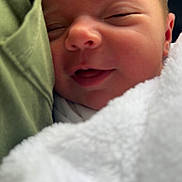 Lïyah participe au concours pour gagner de l'argent avec cette photo : newborn, baby, infant, face, smile, sleepy, blanket, soft, closeup, skin, head, person, child, cute, cozy, wrapped, peaceful, warm, green, fabric