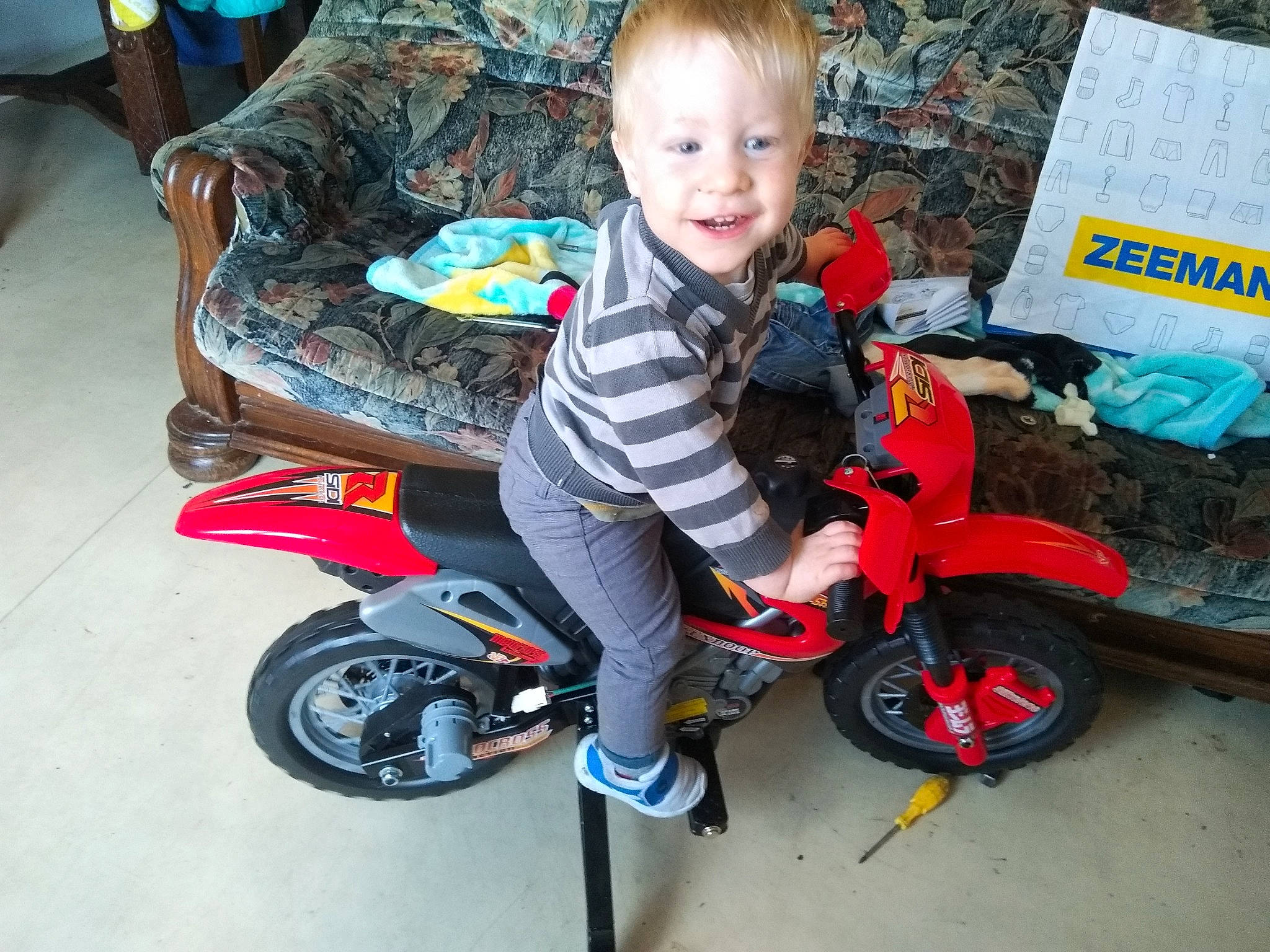 Adryen participe au concours pour gagner de l'argent avec cette photo : car, child, motor_vehicle, motorcycle, person, riding_toy, toddler, vehicle