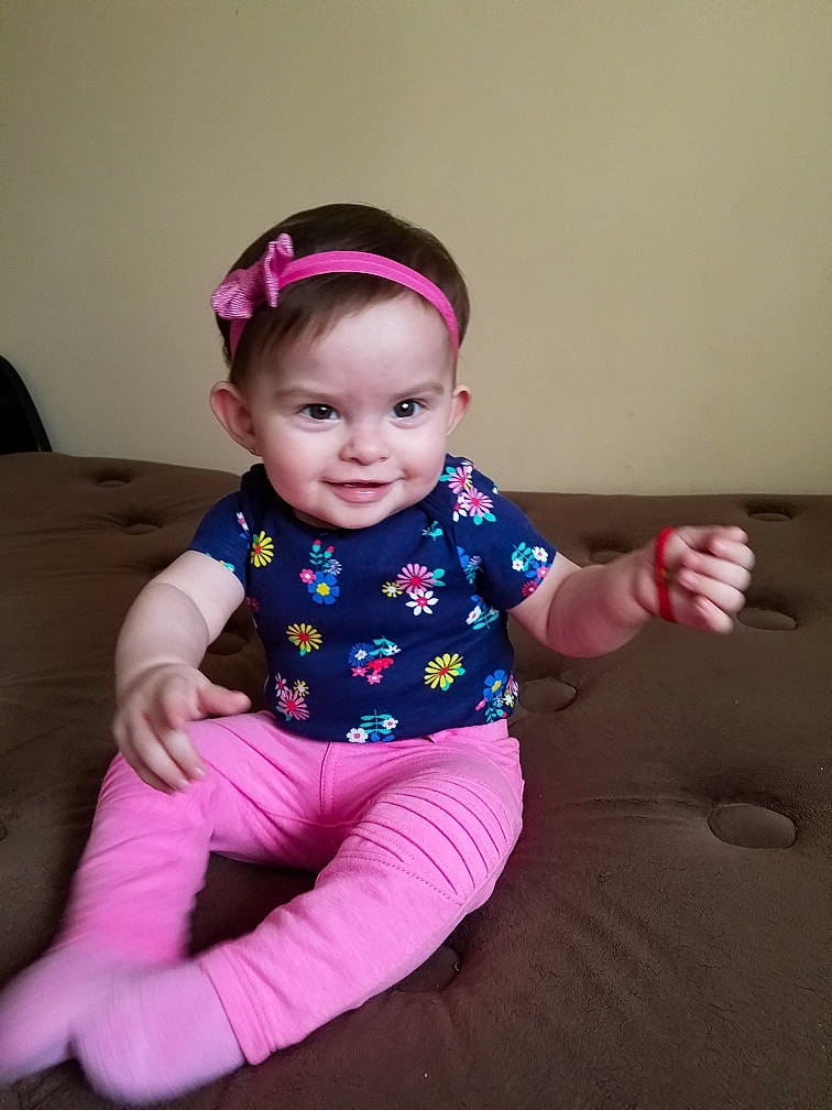 Brittany is registered to the contest to win money with this photo: baby_products, child, day, fun, girl, hair_accessory, headgear, infant, magenta, person, pink, play, product, purple, sitting, skin, smile, textile, toddler