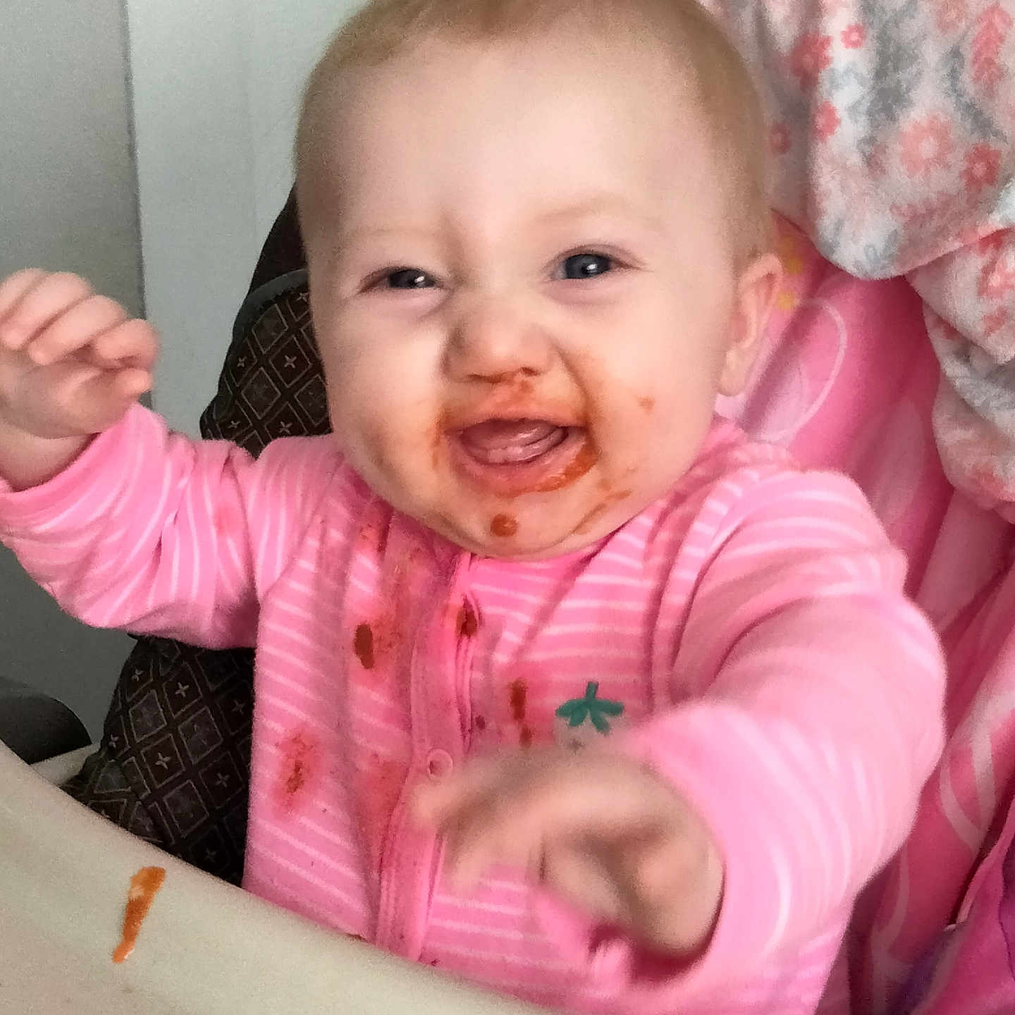Ellye joined the competition — help win amazing prizes! baby, child, cute, expression, fabric, face, feeding_time, food, hands, happy, high_chair, indoor, infant, messy, mouth_open, pink_clothing, smiling, spaghetti_sauce, table, young_child