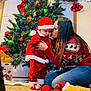 Sneijder is registered to the contest to win money with this photo: baby, carpet, celebration, child, christmas_decorations, christmas_lights, christmas_tree, family_moment, festive_sweater, gift_bag, green_ornament, holiday, indoor, kiss, ornaments, plush_toy, red_clothing, santa_costume, window_blinds, woman