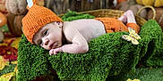 Ezio participe au concours pour gagner de l'argent avec cette photo : baby, infant, orange_hat, knitwear, green_blanket, autumn_leaves, fall_decor, pumpkin, grass, cute, portrait, lying_down, seasonal, indoor, decorations, child, soft_texture, colorful, baby_clothing, holiday_theme