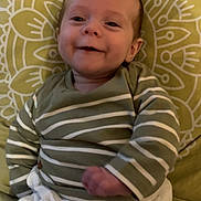 Ezio a rejoint le concours — aidez-le/la à gagner de superbes lots ! baby, smiling, striped_sweater, white_pants, buttons, cushion, yellow, face, child, infant, happy, cute, clothing, indoors, portrait, sitting, young_child, person, cozy, candid