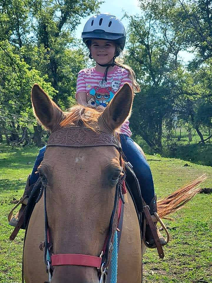 Liberty is registered to the contest to win money with this photo: bit, bridle, equestrian_helmet, equestrianism, halter, head, headgear, headwear, helmet, horse, horse_supplies, horse_tack, joy, mammal, outdoor_recreation, person, plant, saddle, smile, sports_equipment