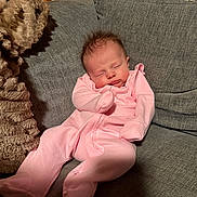 Maybel joined the competition — help win amazing prizes! baby, sleeping, pink_onesie, couch, gray_couch, plush_blanket, wooden_wall, infant, cozy, indoors, child, relaxing, peaceful, home, furniture, soft_texture, portrait, resting, newborn, cute