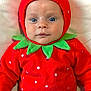 baby, child, costume, strawberry, red_clothing, green_leaves, polka_dots, infant, blue_eyes, face, cute, portrait, lying_down, soft_texture, hooded_outfit, hands, white_background, skin, looking_at_camera, adorable