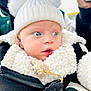 baby, infant, blue_eyes, white_hat, pom_poms, sherpa_jacket, pacifier, close_up, outdoor, winter_clothing, cute, child, portrait, soft_texture, warm_clothing, curious, face, person, headwear, expression