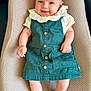 baby, infant, smile, dress, green_dress, white_collar, cushion, fabric, texture, barefoot, skin, child, cute, portrait, lying_down, comfort, indoors, person, happy, small_hands