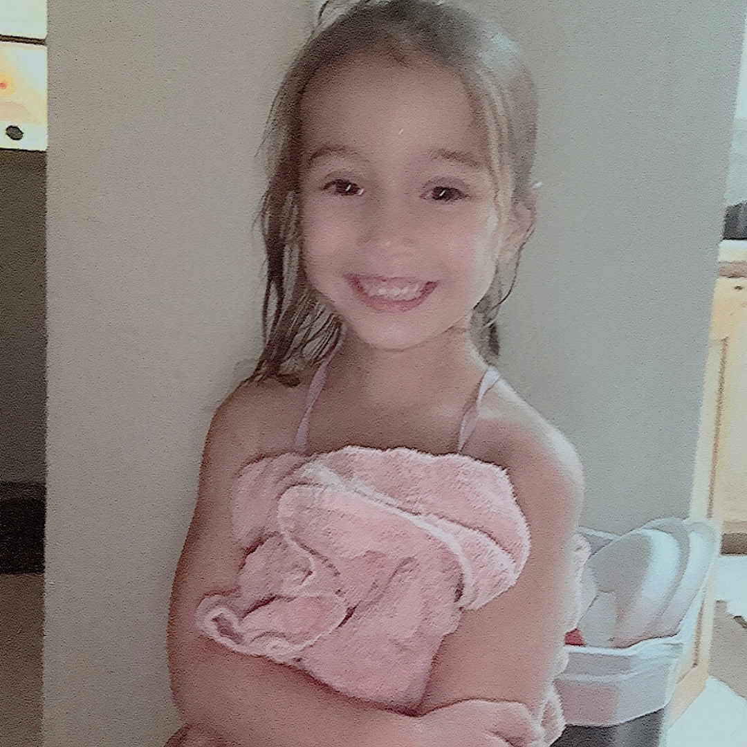 Maliah is registered to the contest to win money with this photo: child, smiling, towel, wet_hair, indoor, bathroom, trash_bin, young_girl, happy, person, cute, portrait, home, light_switch, kitchen, wrapped, standing, skin, arms_crossed, casual