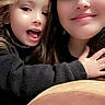 Maliah is registered to the contest to win money with this photo: child, woman, smile, hug, selfie, face, happy, indoor, cozy, black_clothing, cushion, pink, brown, long_hair, casual, togetherness, portrait, closeup, family, affection