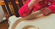 Paisley Rae is registered to the contest to win money with this photo: toddler, child, high_chair, snack, red_clothing, indoor, wooden_chair, wooden_floor, face, hand, table, doodle, star_doodle, cute, baby, feeding, furniture, person, smiling, cozy