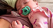 Paisley Rae is registered to the contest to win money with this photo: baby, casual, child, closeup, comfort, couch, cozy, cushion, face, flamingo_pattern, hand, home, indoor, pacifier, person, pink_clothing, relaxation, resting, sleeping, soft_fabric